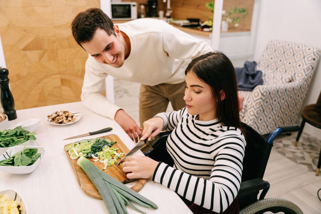helping independent skills A couple cooking together, highlighting inclusivity and togetherness in the kitchen.